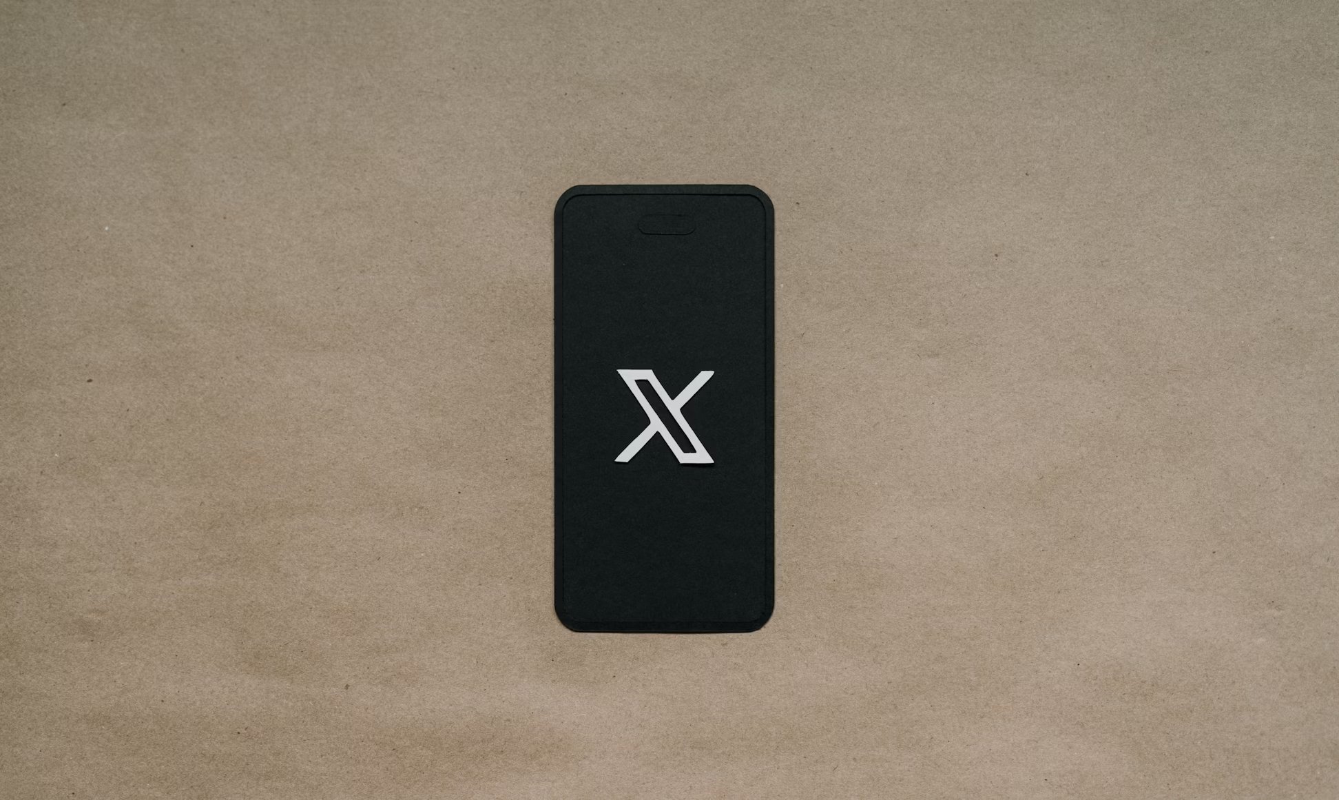 Logo da X em smartphone de papel