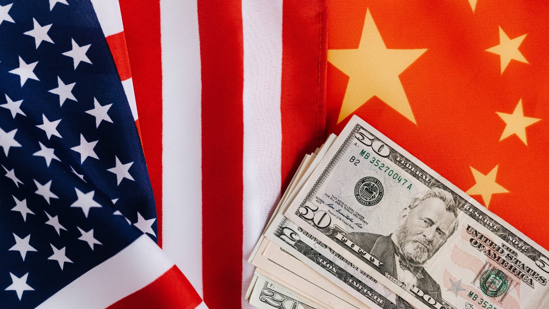 Bandeira da China e dos EUA com dinheiro no meio