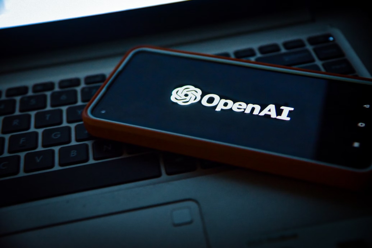 logo da openai em smartphone em cima de teclado de computador