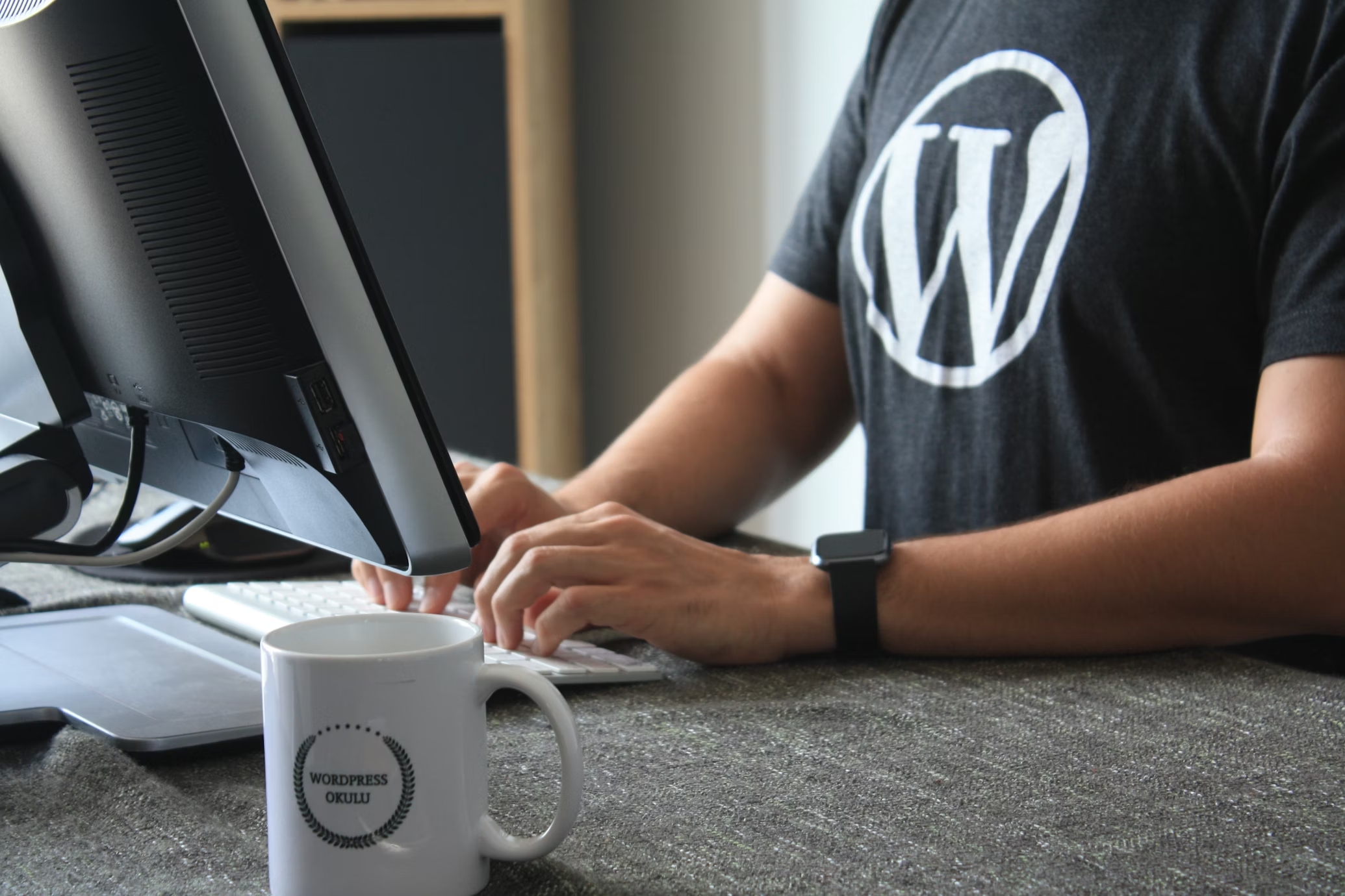 pessoa com camisa do WordPress a mexer em computador