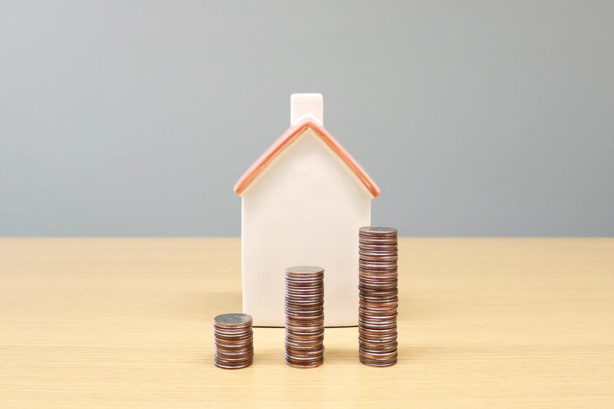 casa com moedas em frente
