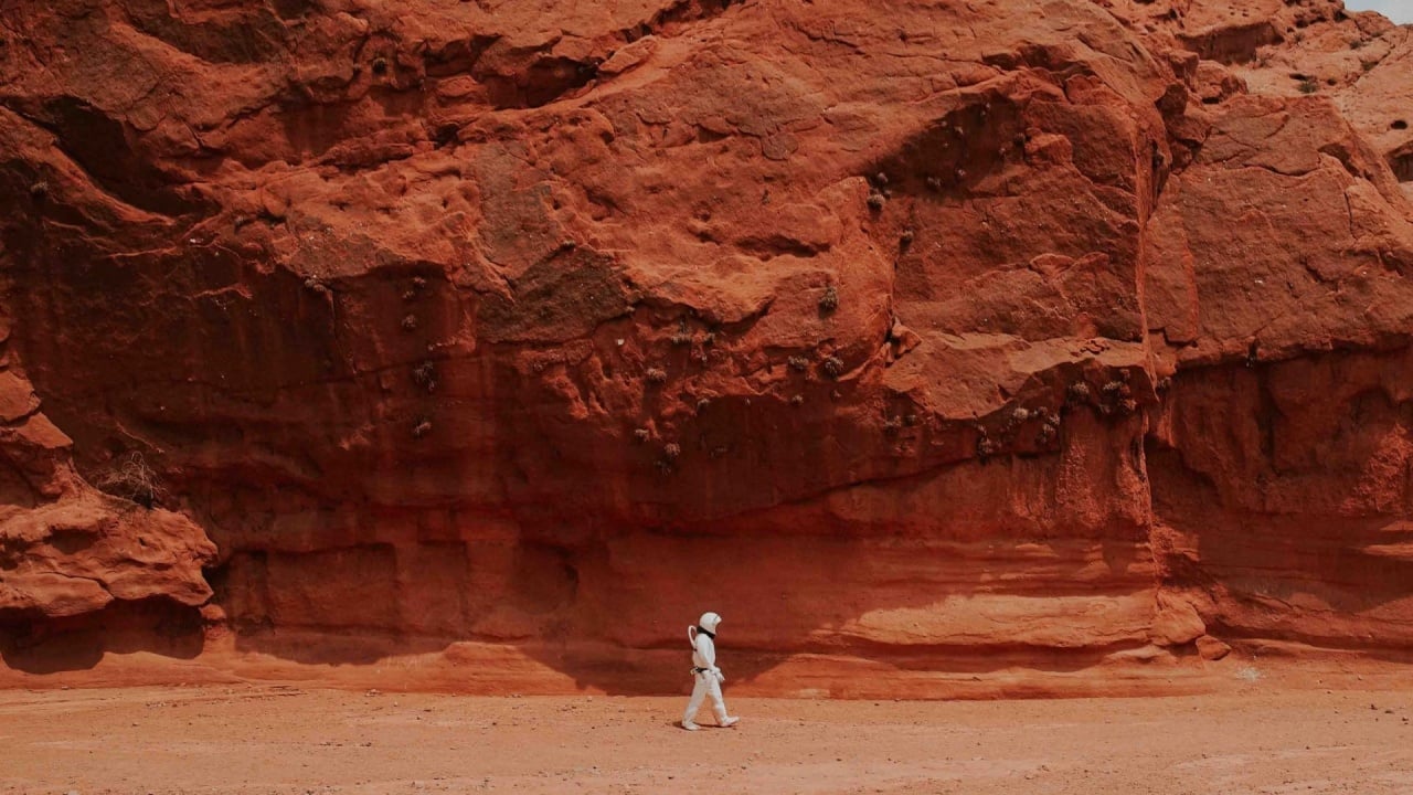 Pessoa a andar com fato de astronauta em paisagem similar a marte