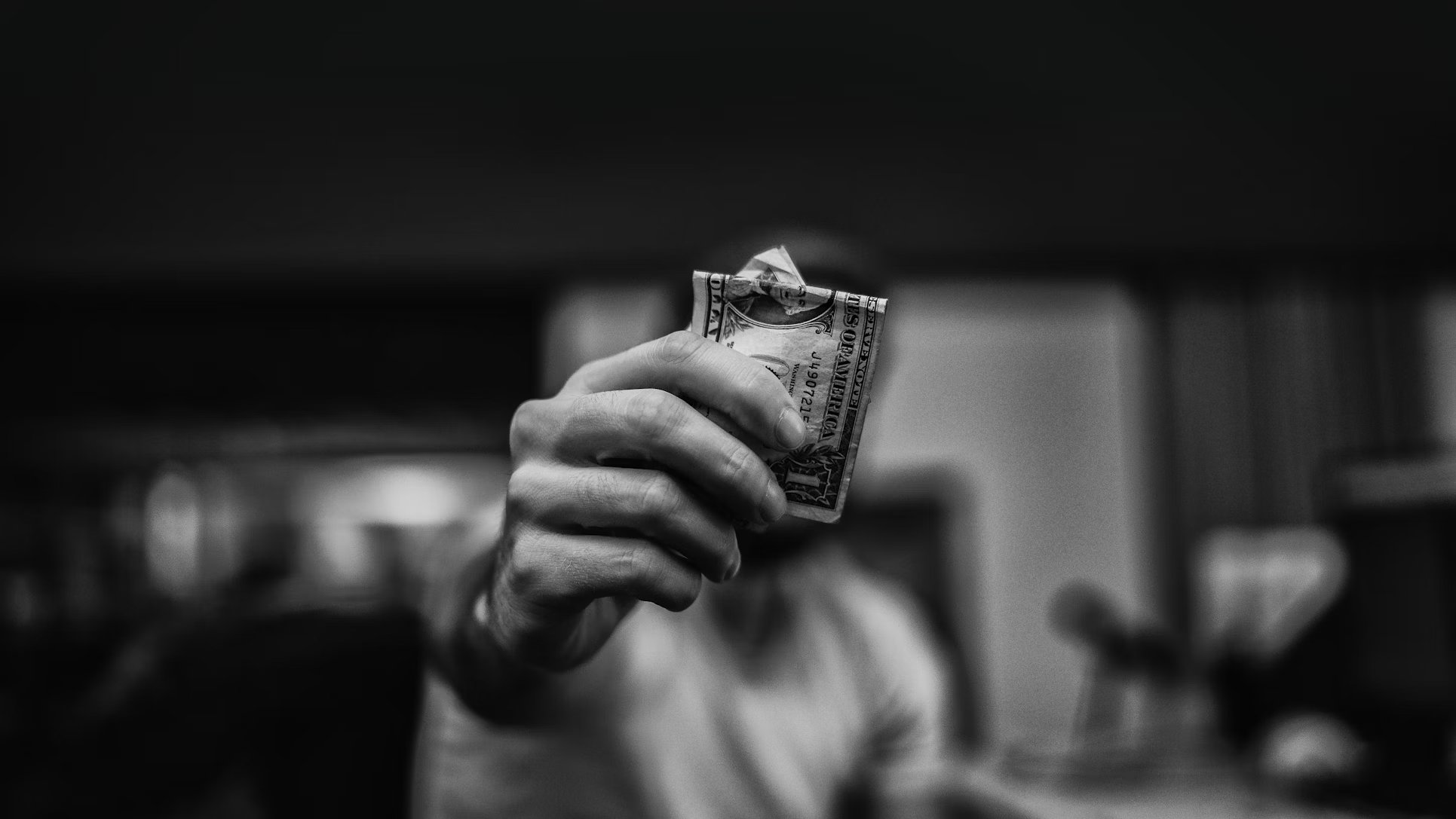 Pessoa a segurar numa nota americana