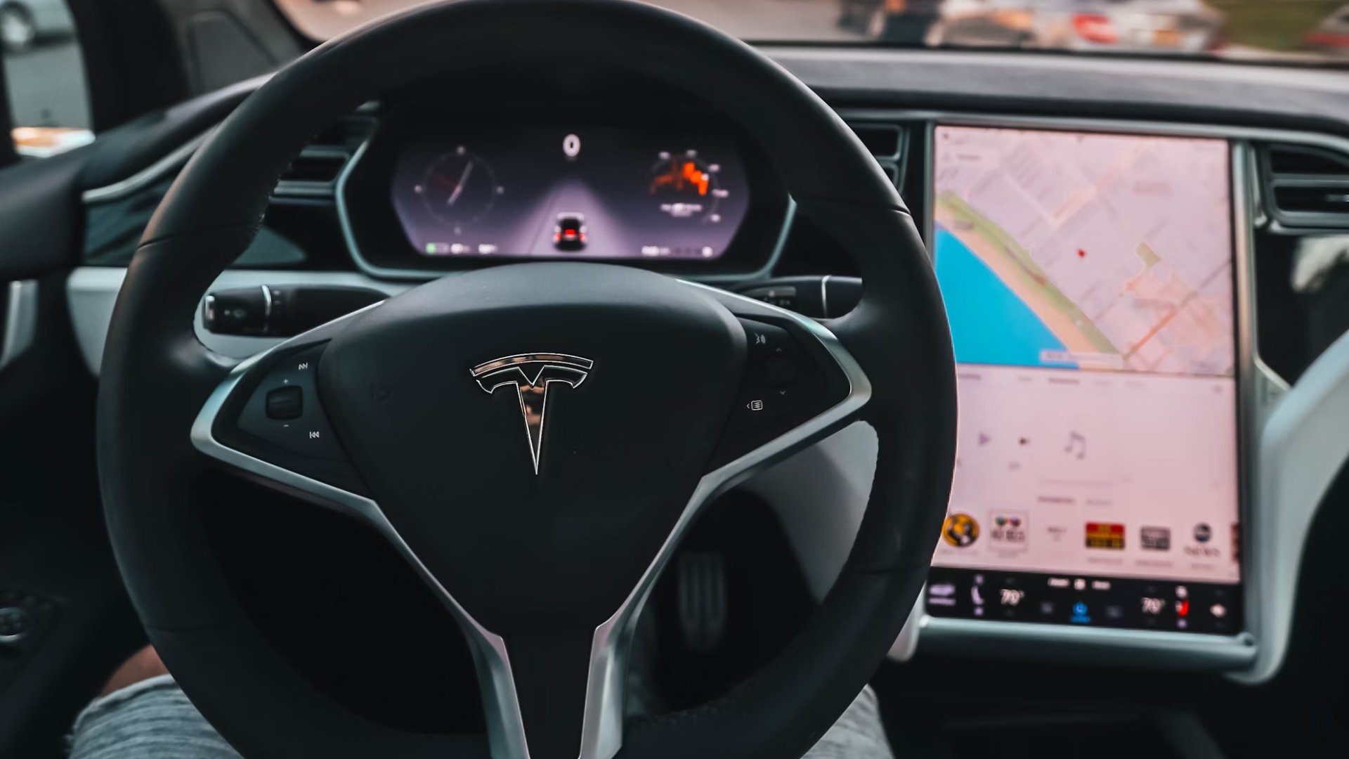 Interior do Tesla com destaque no logo e volante