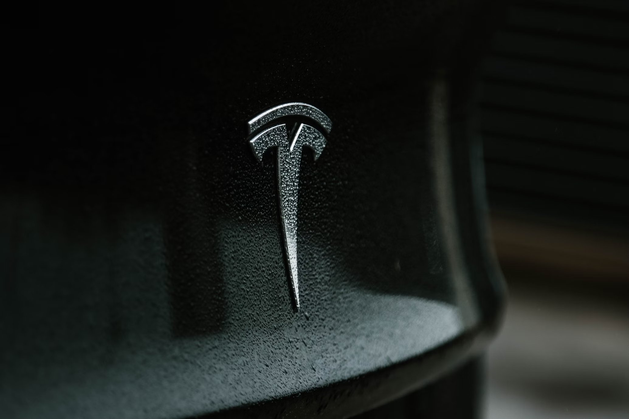 Logo da Tesla em veículo da marca preto
