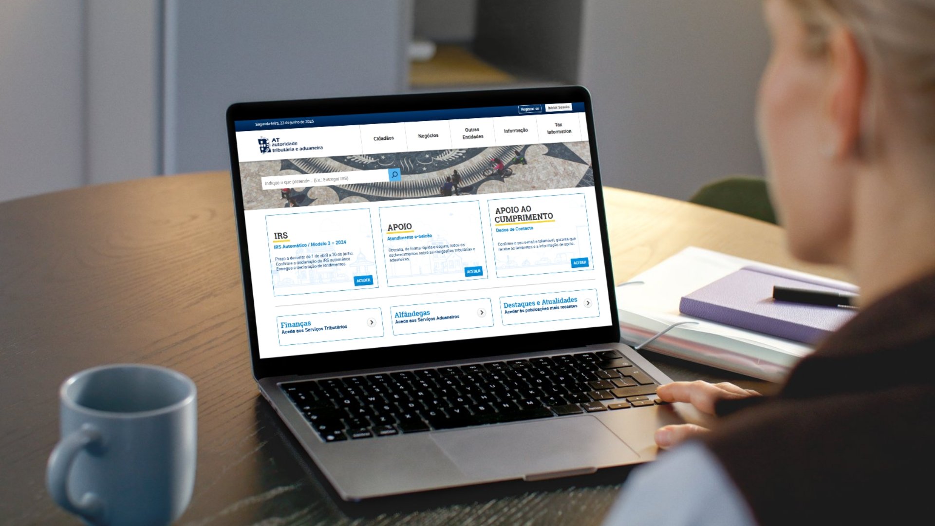 Pessoa em frente de computador com portal das finanças aberto