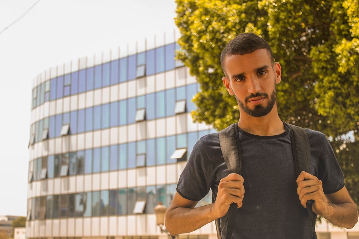 Jovem de mala às costas para o ensino superior