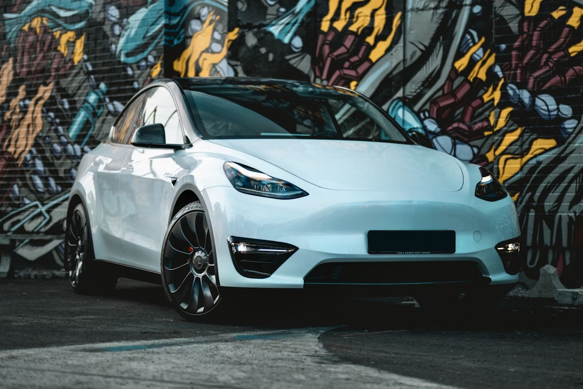 Tesla em frente de uma parede com graffites