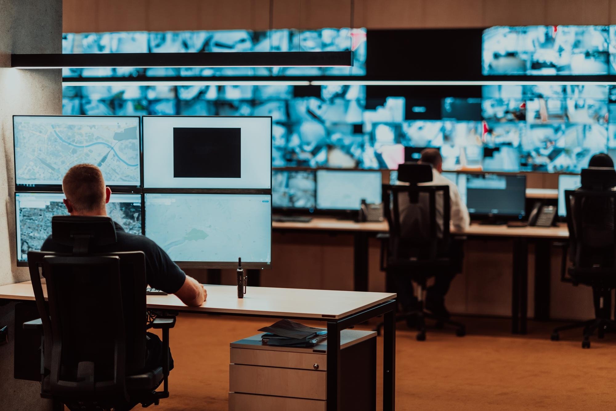 autoridades em frente de sistema de computadores