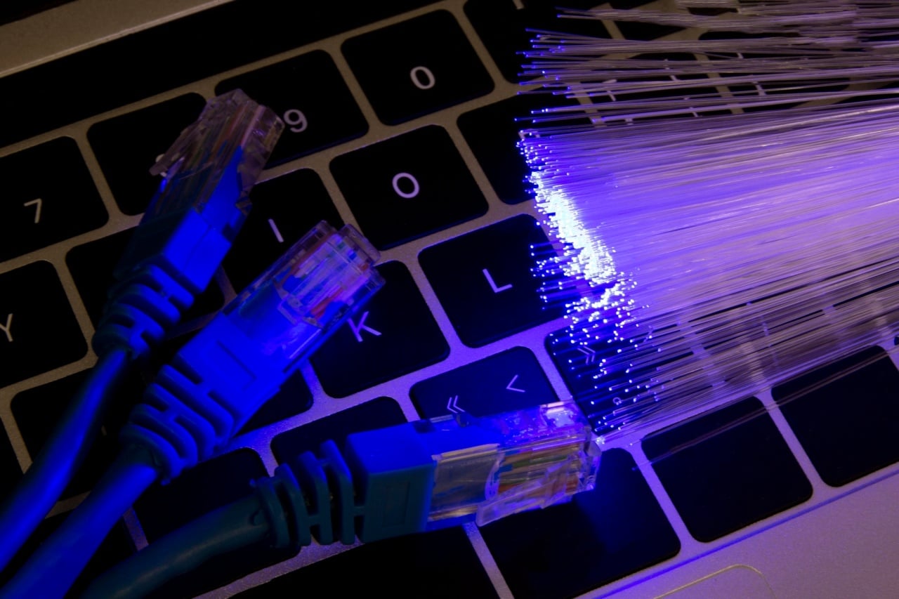 Cabo de internet e fibra sobre teclado de computador
