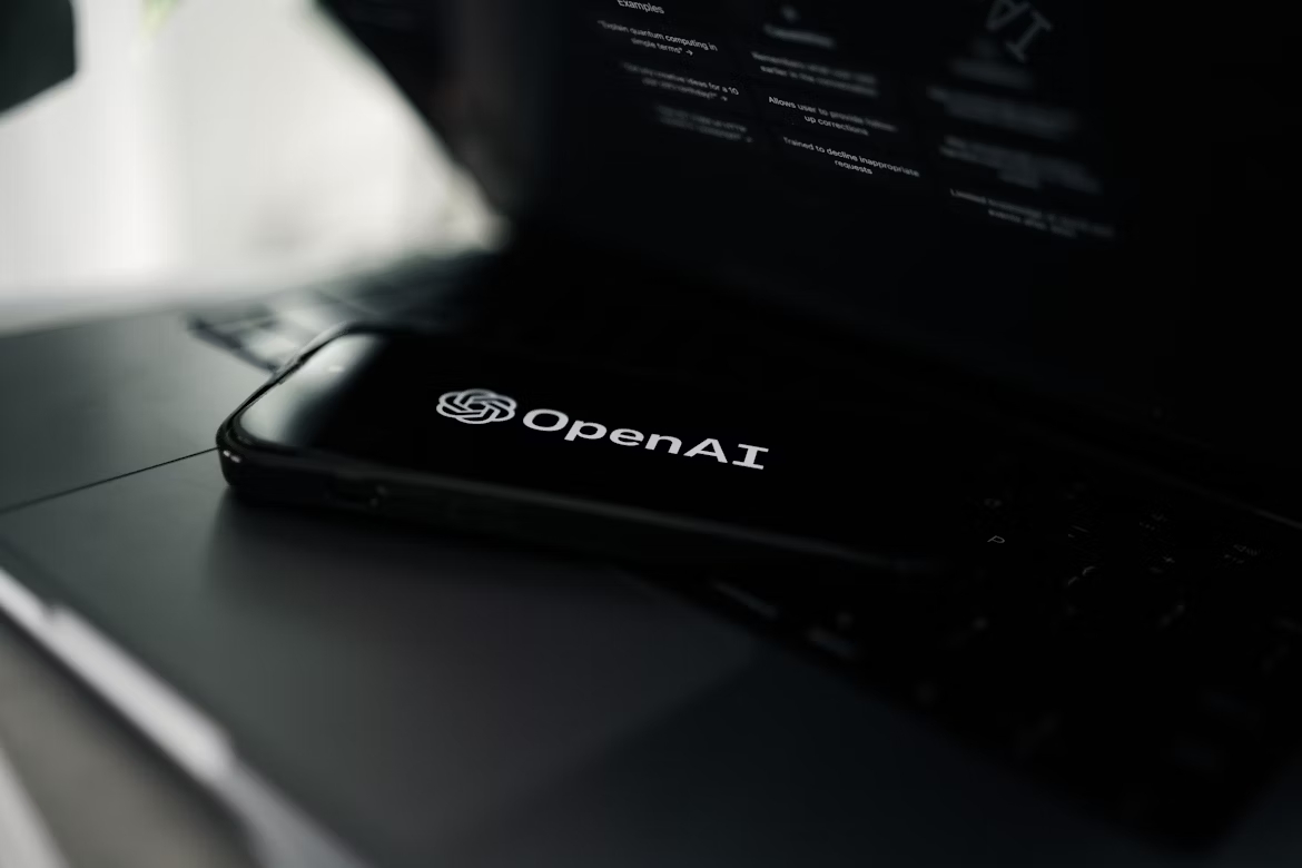 OpenAI em smartphone sobre um computador