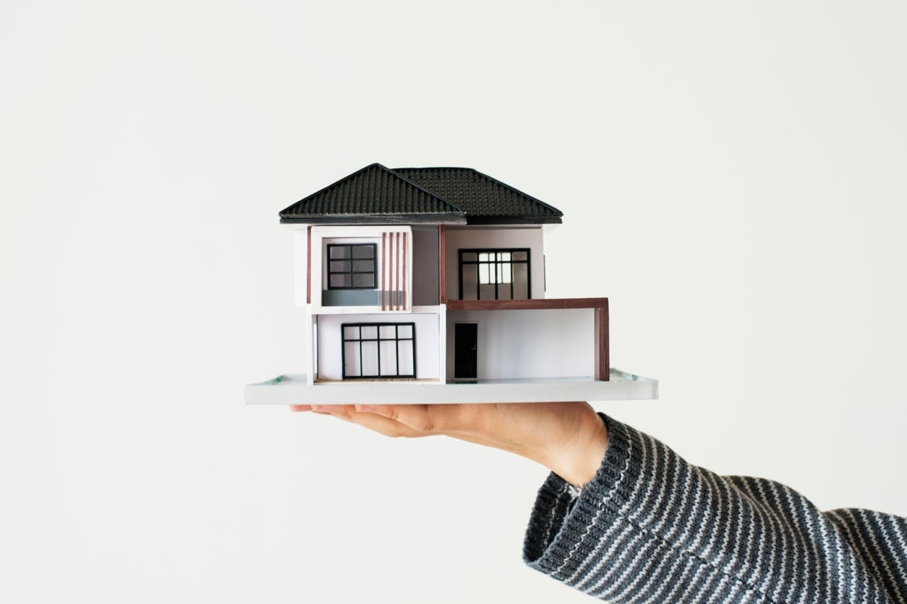 casa em miniatura em cima de uma mão