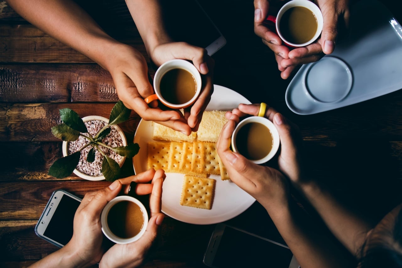pequeno almoço com várias pessoas a tomarem chá