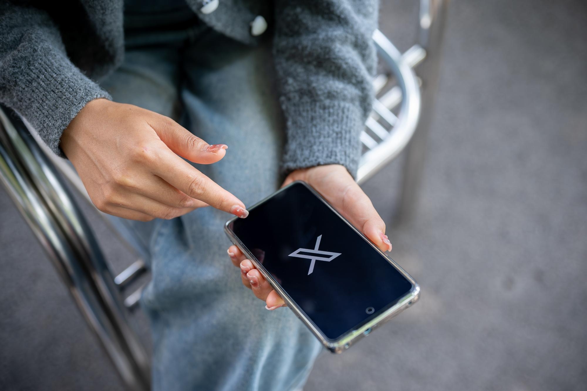 pessoa a usar smartphone na x