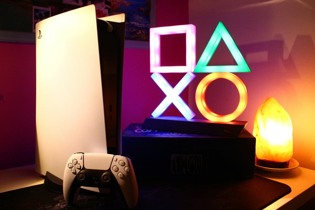 playstation 5 com comando ao lado, e um icone do logo da playstation em LED