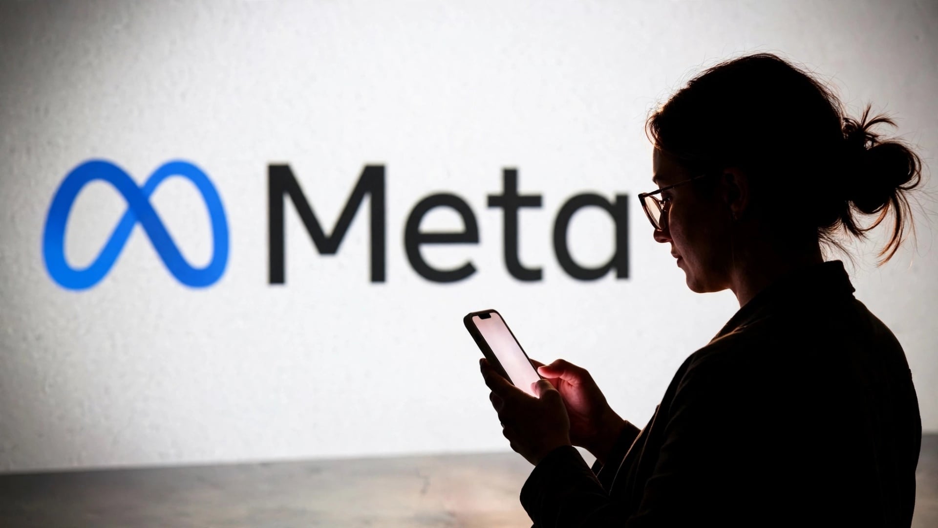 logo da Meta com pessoa a usar smartphone
