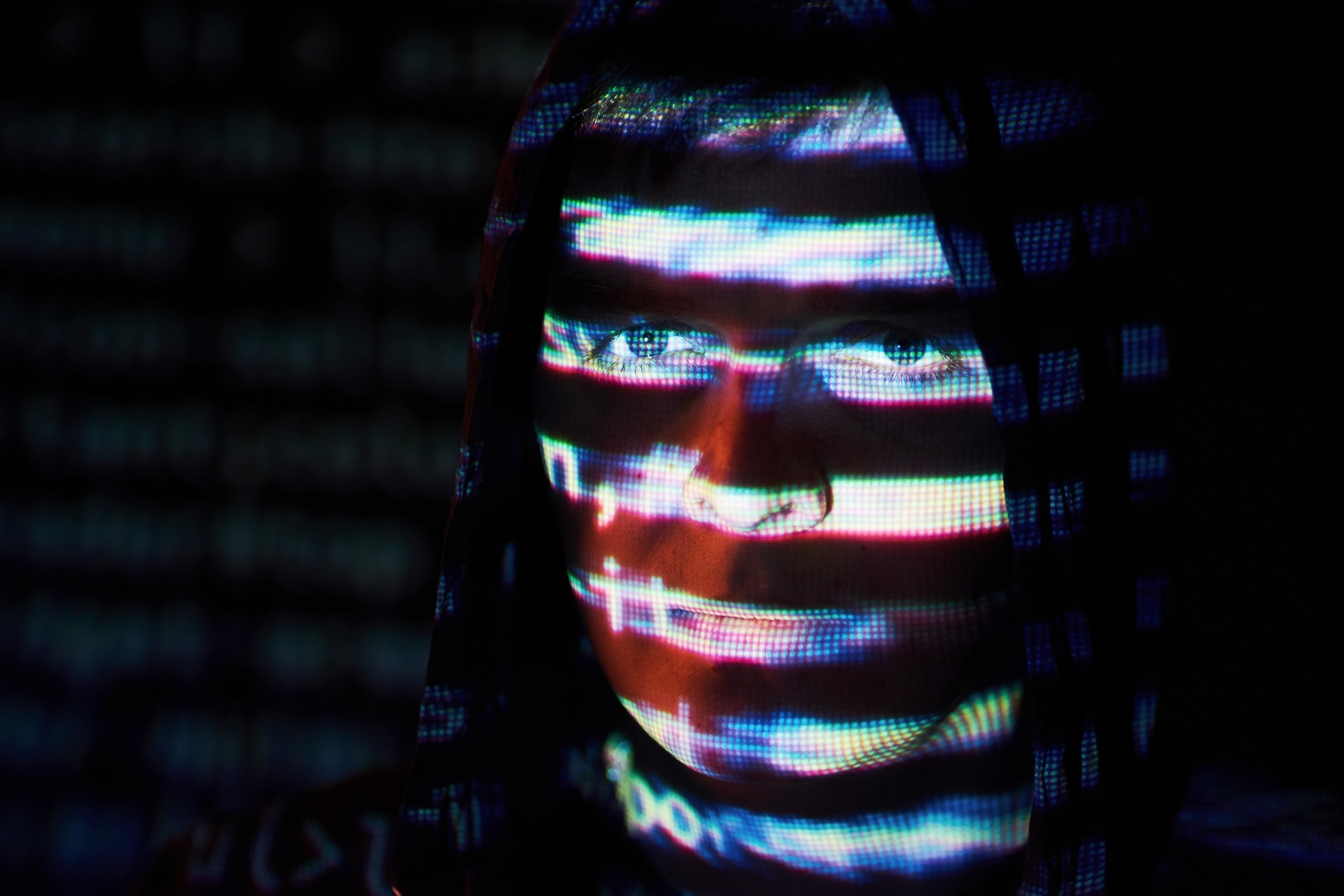 Hacker em frente de linhas de TV