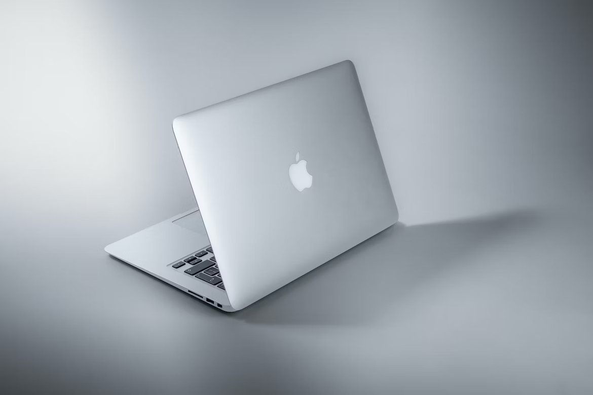 Macbook branco em cima de mesa