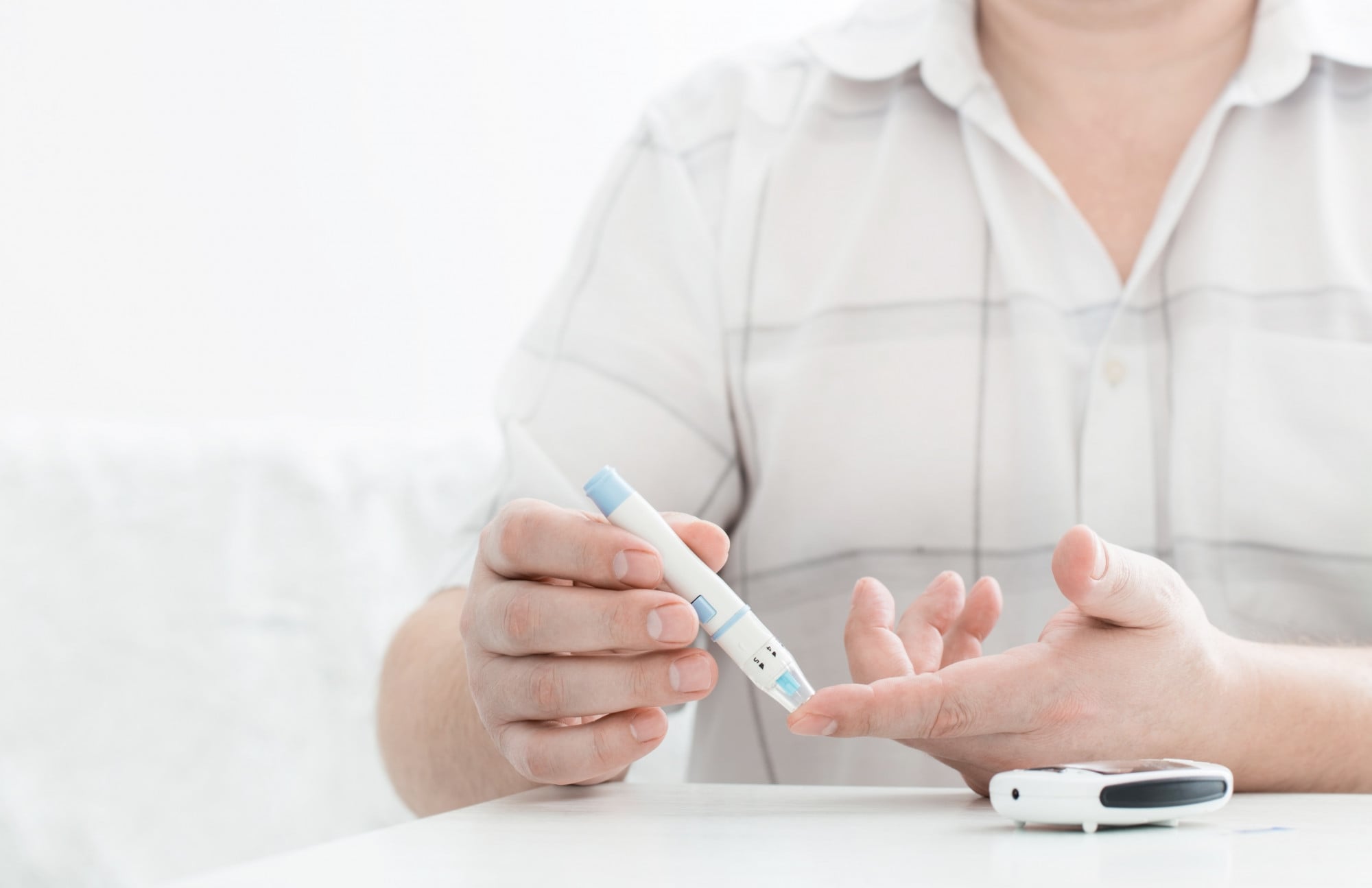 Pessoa a picar o dedo para controlo dos diabetes