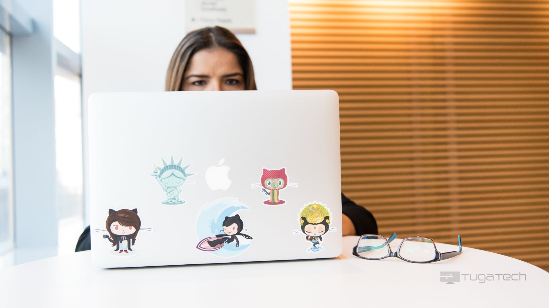 Senhora em frente de computador com selos do Github