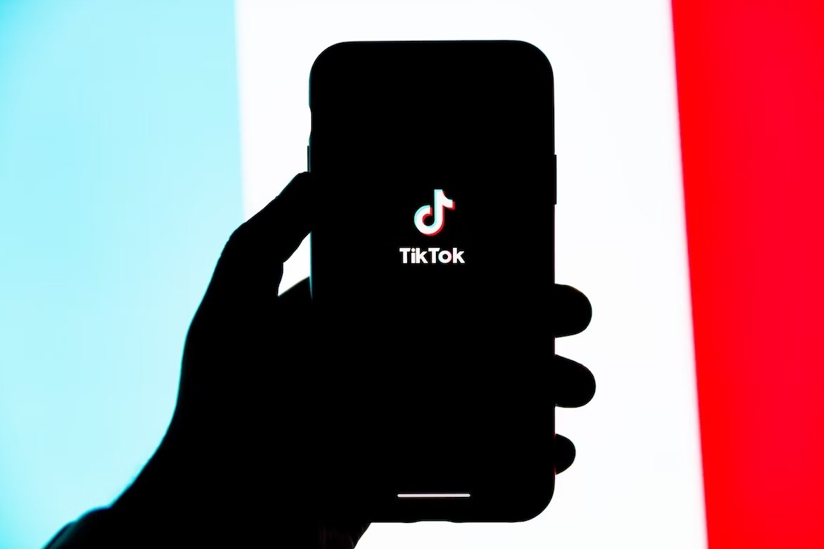 TikTok em smartphone com bandeira colorida na parte traseira