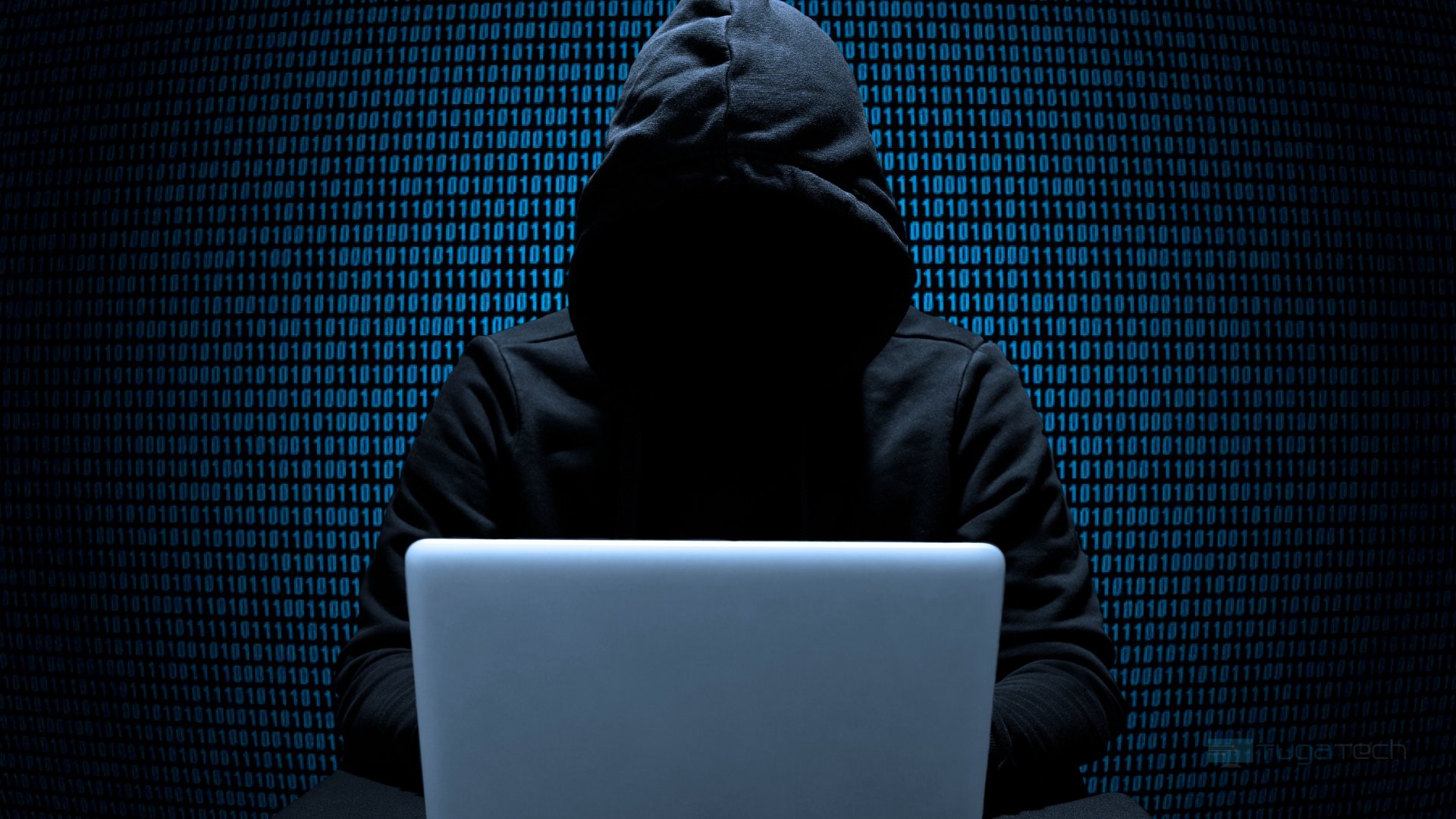 hacker em frente de computador com capuz