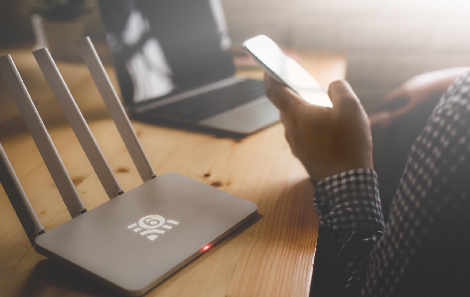 Router wifi com utilizador a mexer em telemovel