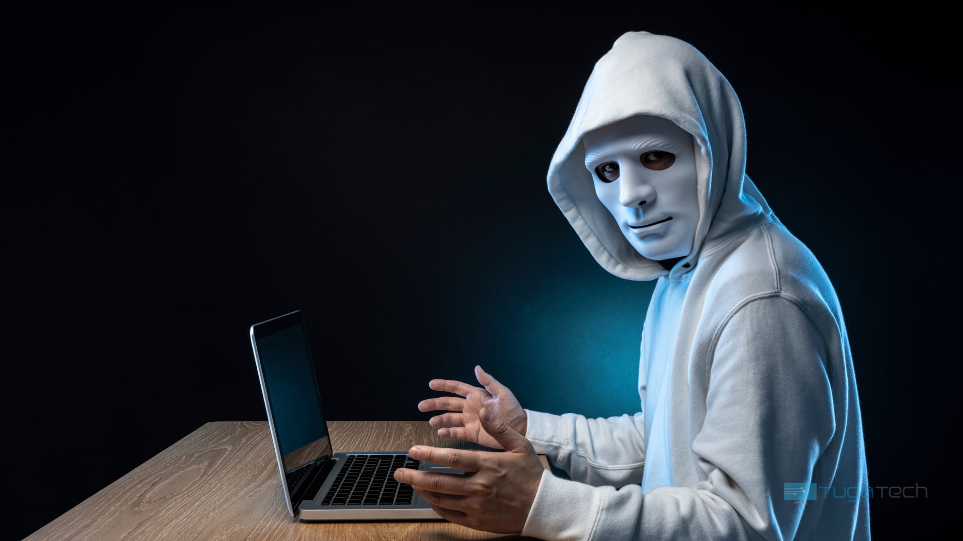 Hacker em frente de computador numa mesa