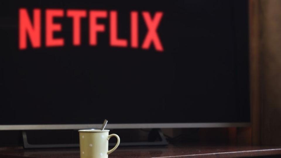 Netflix junto a uma TV e chavena