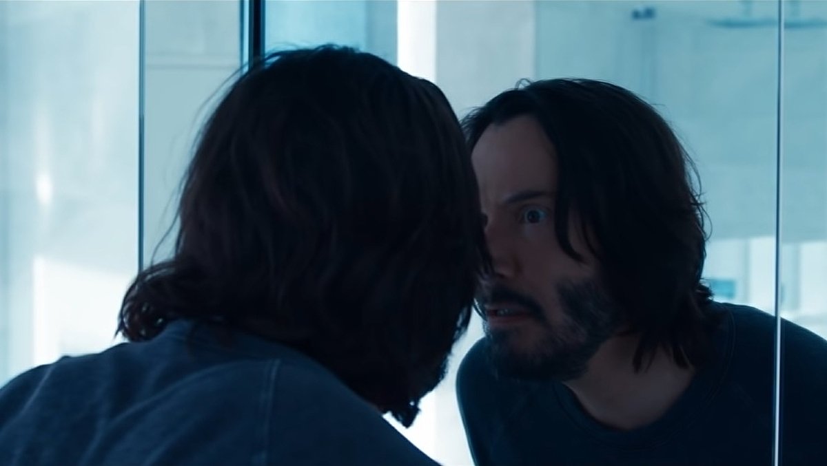 Keanu Reeves a olhar para o espelho