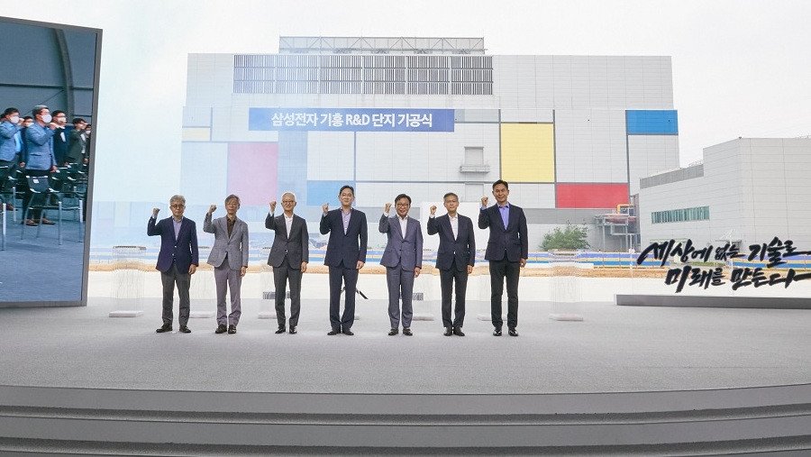 Samsung executivos em frente de projeto fábrica