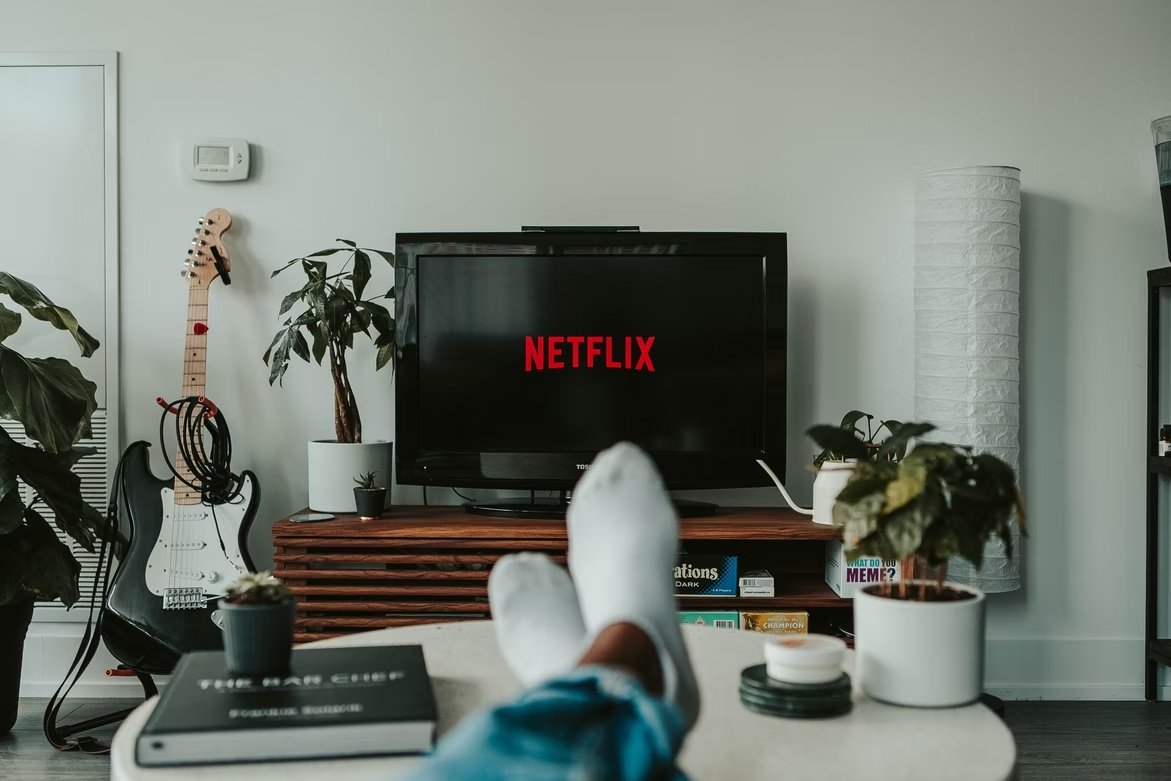 Netflix com pessoa sentada na tv